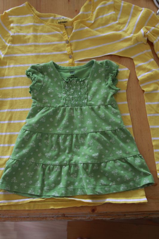 a baby dress laid over fabric to use as a pattern