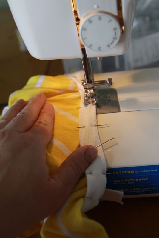 sewing binding on a sewing machine, binding stretched so fabric is flat