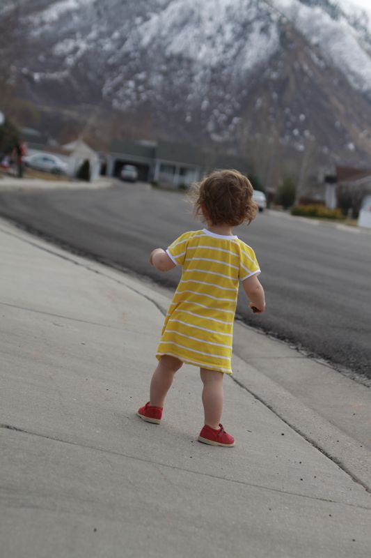 A little girl standing on a sidewalk
