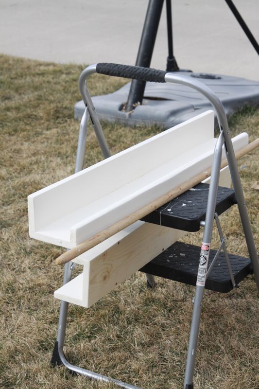 painted shelf resting on a step stool to dry