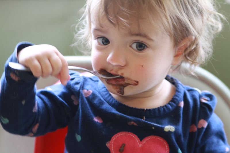 A baby girl with brownie batter on her face