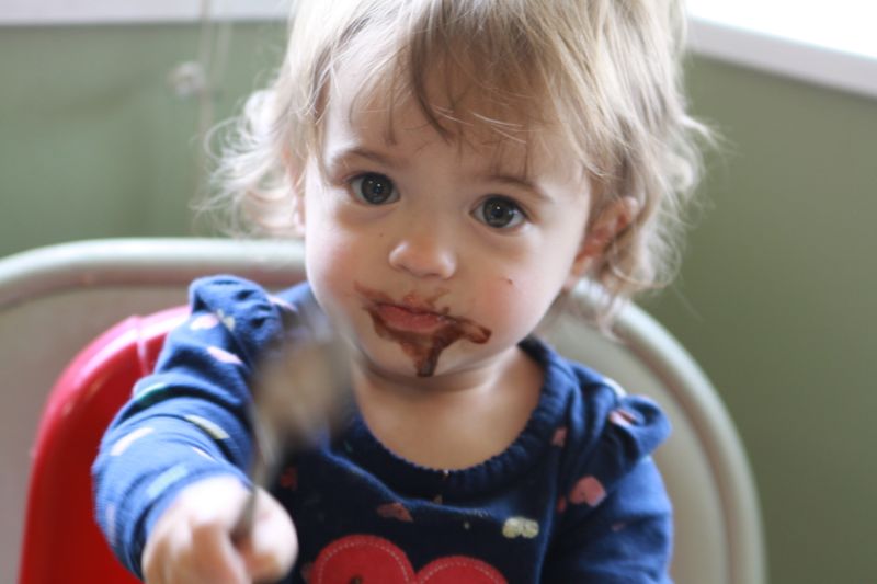 A little girl eating brownie batter