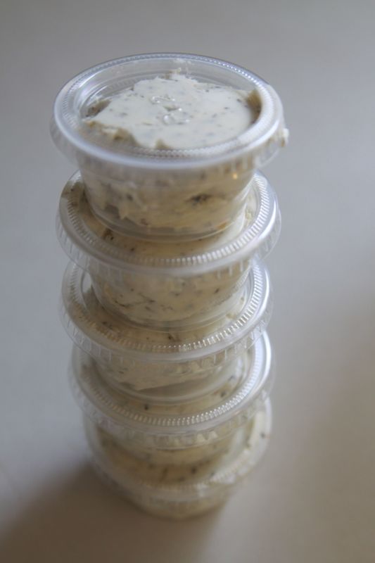 garlic herb butter spread in small plastic containers