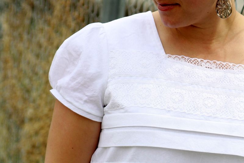 A woman wearing a white blouse with puffed sleeve