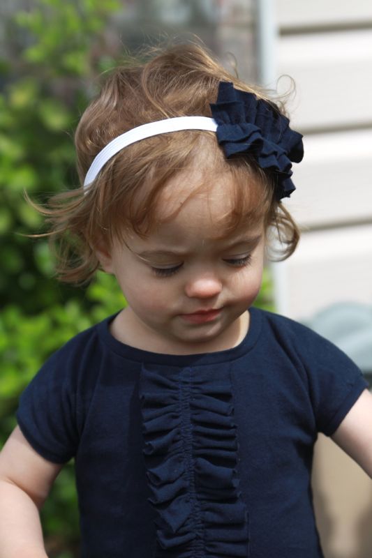A little girl with ruffle front dress and ruffled headband
