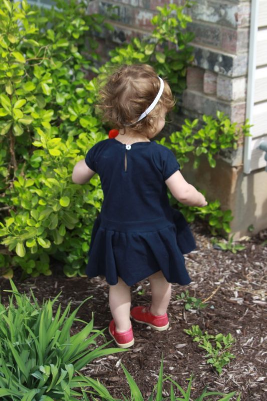 A little girl standing in a garden