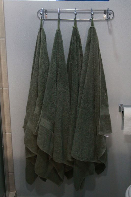 towels hanging on hooks on bathroom wall