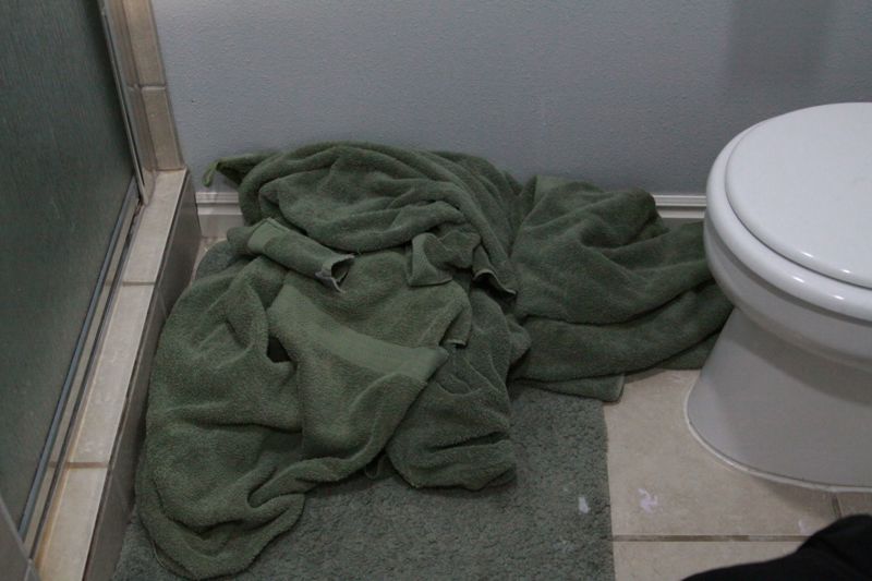 dirty towels on the ground of a bathroom