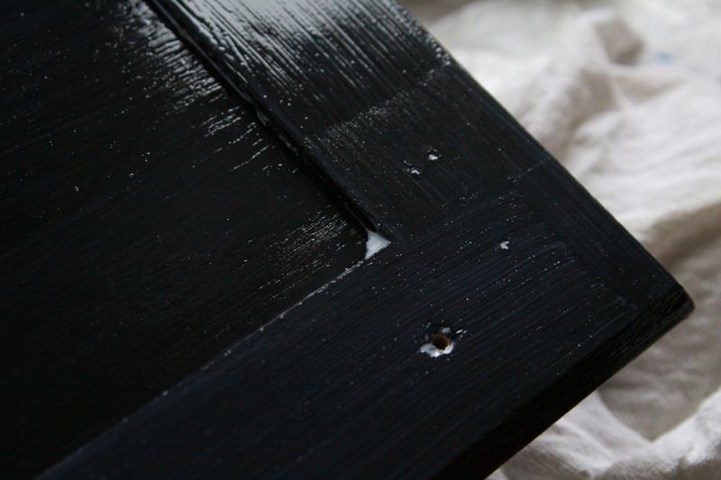 cabinet door painted black, with little bit of glaze collected in the corner