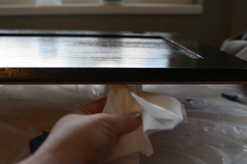 wiping drips from under a painted cabinet door