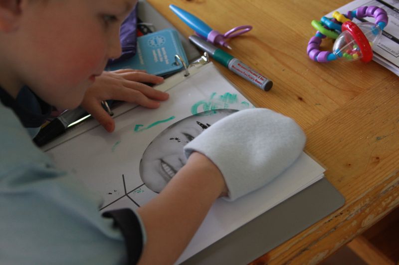 boy using fabric mitt to erase dry erase marker