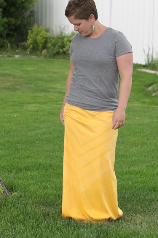 A woman wearing a grey t-shirt and yellow maxi dress