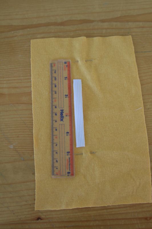 Yellow fabric pinned, with ruler and piece of elastic