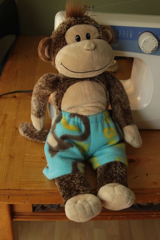 A stuffed animal monkey wearing pajama shorts