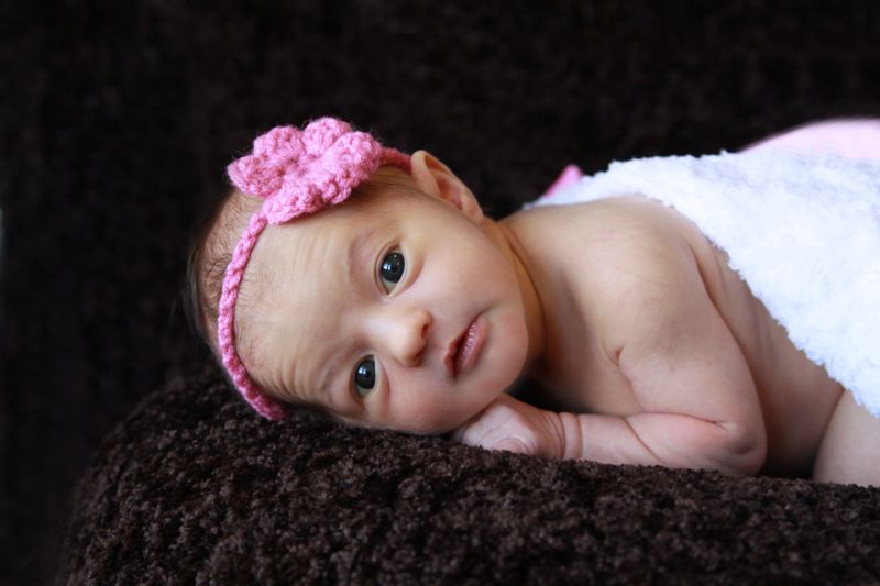 A little baby girl lying on a bed with her eyes open