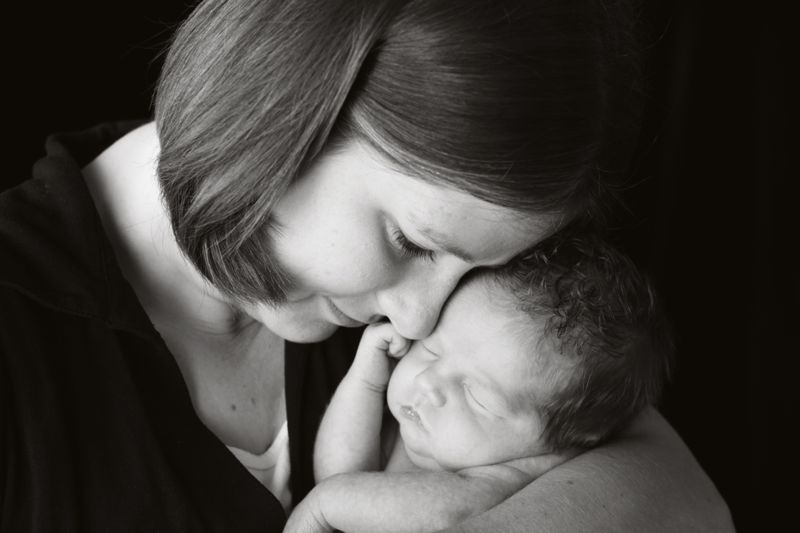 A mother snuggling her new baby, heads touching