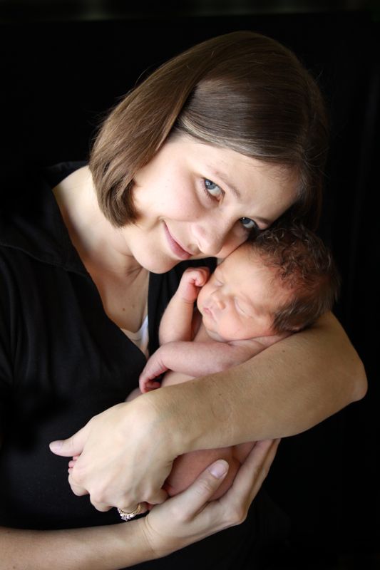 A mother holding her baby up close to her face, heads touching