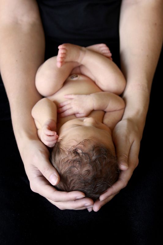 Hands holding a newborn baby