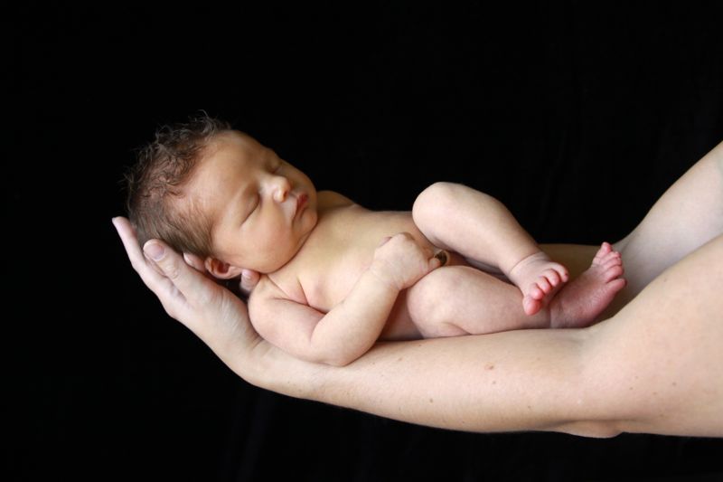 A newborn baby on an extended arm