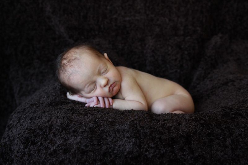 A newborn baby laying on a blanket - newborn photo poses
