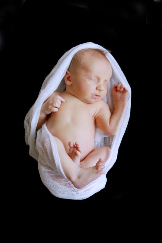 A newborn baby wrapped in white cloth