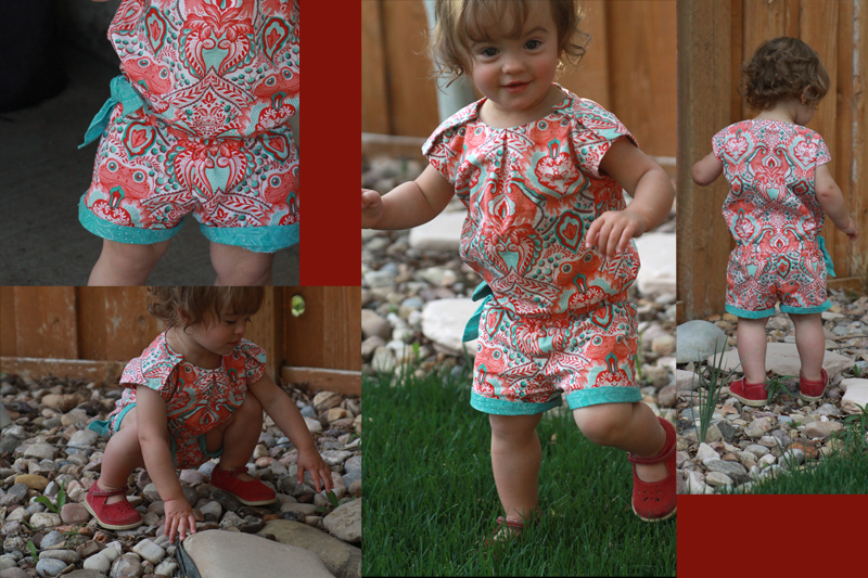 A little girl wearing a brightly colored romper