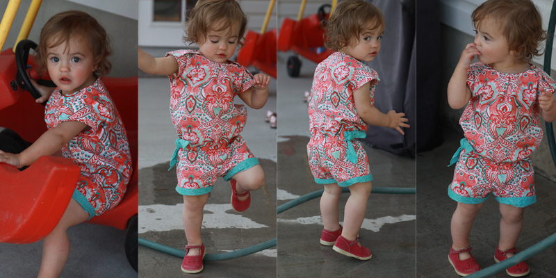 A little girl wearing a shortie romper