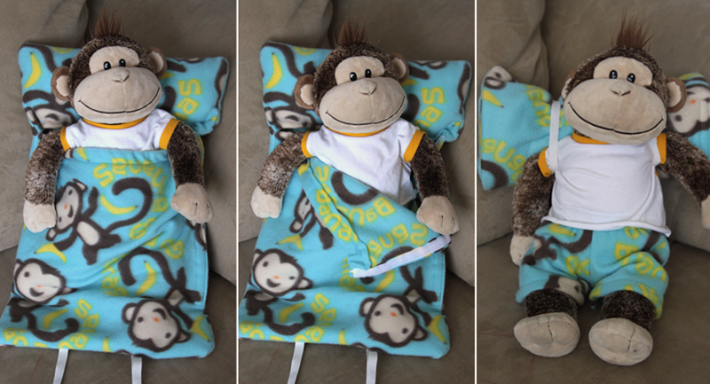 A stuffed animal monkey inside a sleeping bag