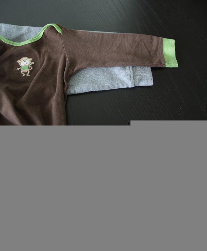 A baby shirt with sleeve placed over the mens sweater sleeve