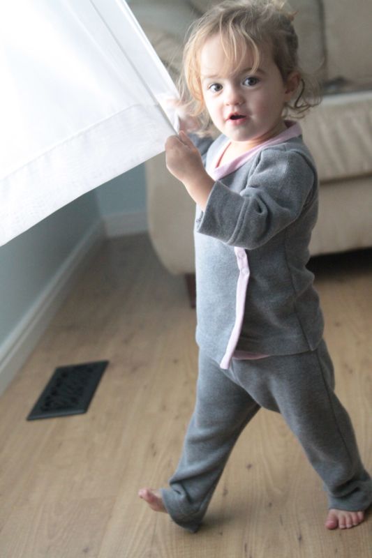 A little girl playing around wearing pajamas