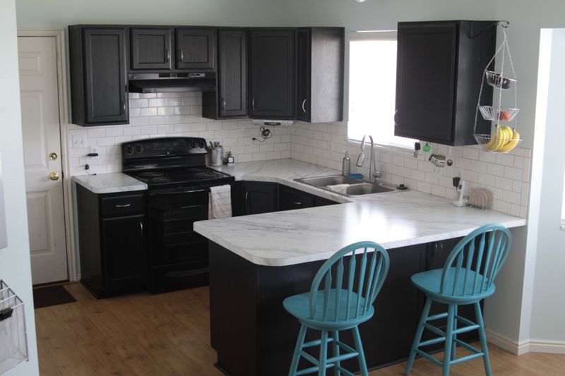 A kitchen with cabinets painted black
