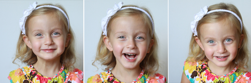 A toddler girl laughing and looking at the camera