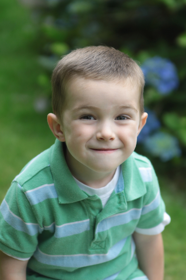 A toddler boy making a fake smile for the photograph
