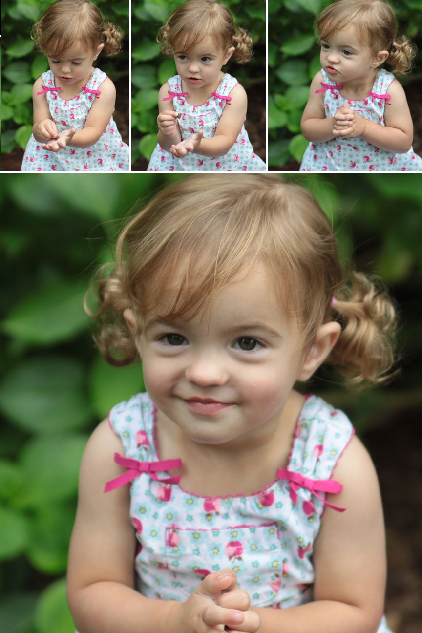 A baby girl holding something in her hand and smiling