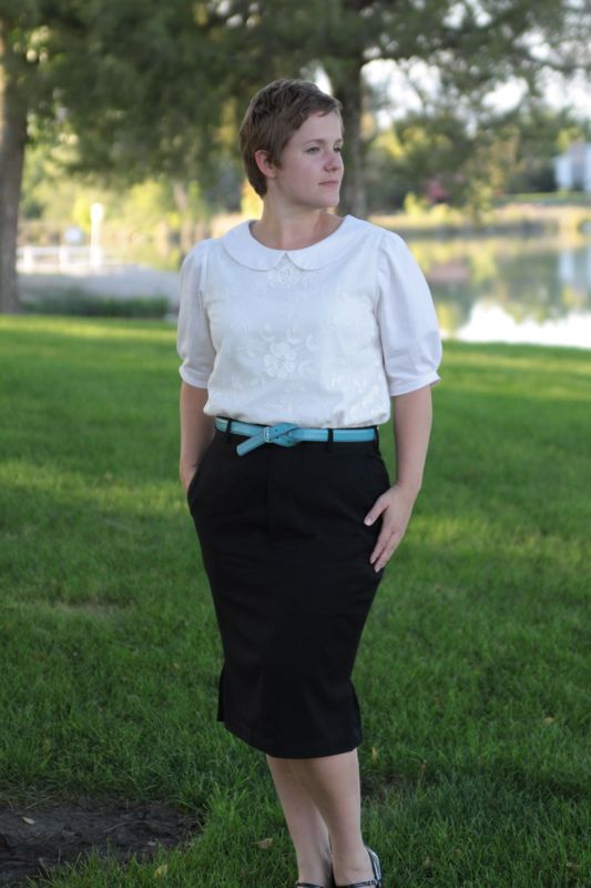 A woman in a white blouse and knee length black pencil skirt