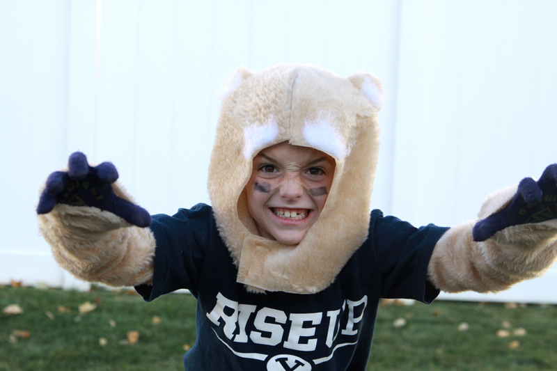 A little boy growling in a cosmo cougar costume