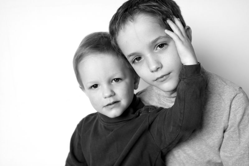black and white photo of two little boys in front of a white background