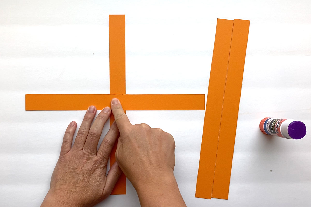 Two orange strips glued together to make a plus sign