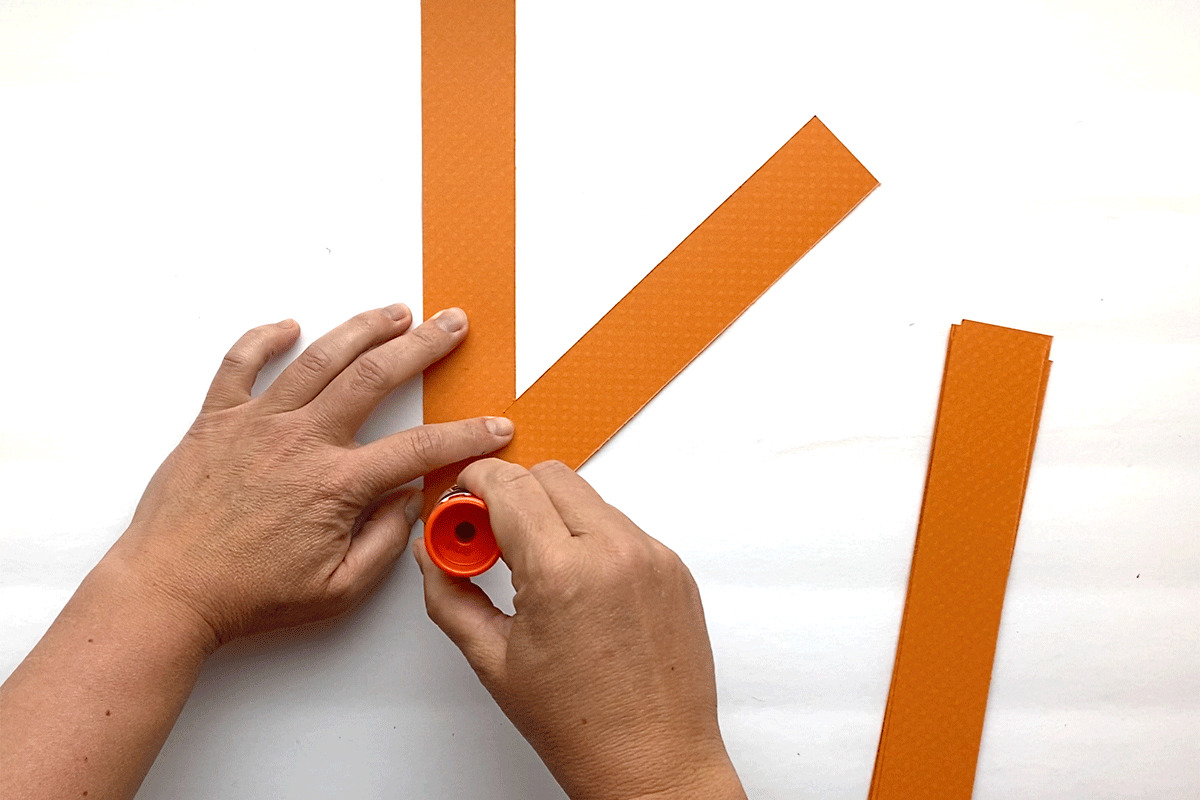 Gluing orange paper strips together