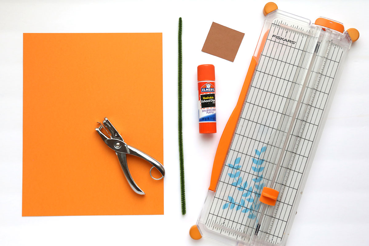 Supplies: orange paper, green pipe cleaner, hole punch, glue stick, paper trimmer, scrap of brown paper