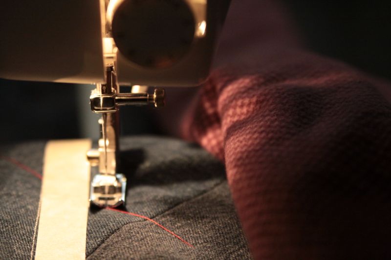 Sewing a denim quilt with masking tape used to mark the sew lines