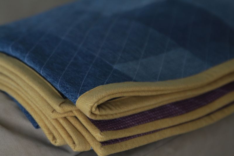 Close up of yellow edge binding on denim quilt