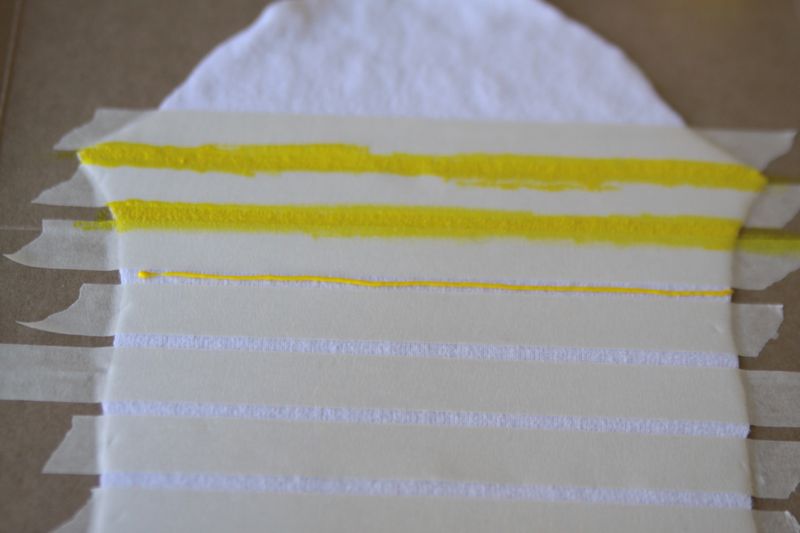 yellow paint in between the masking tape stripes