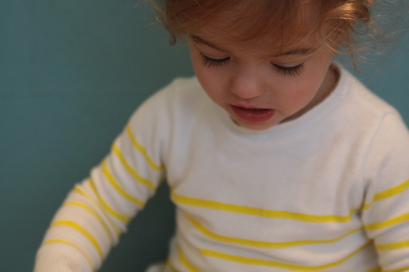 Closeup of little girl wearing white and yellow striped sweater