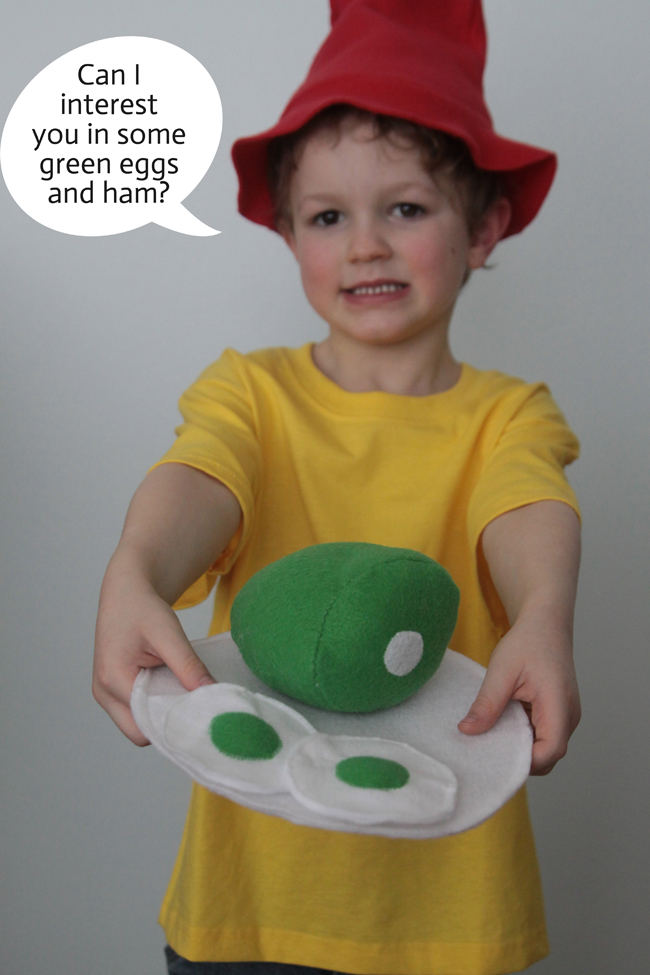 A little boy that is holding green eggs and ham