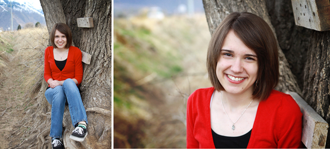A girl sitting against a tree trunk