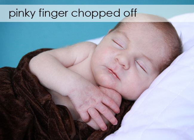 A baby with hand under his chin; one of the fingers is folded in so not visible