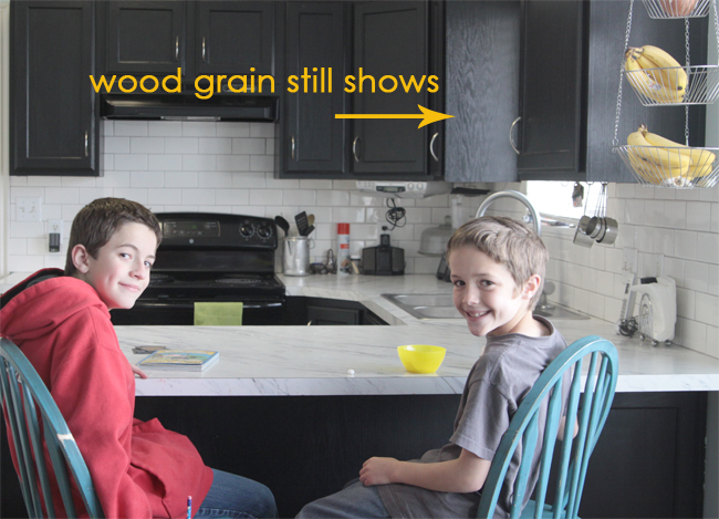 kids in a kitchen where cabinets were painted black