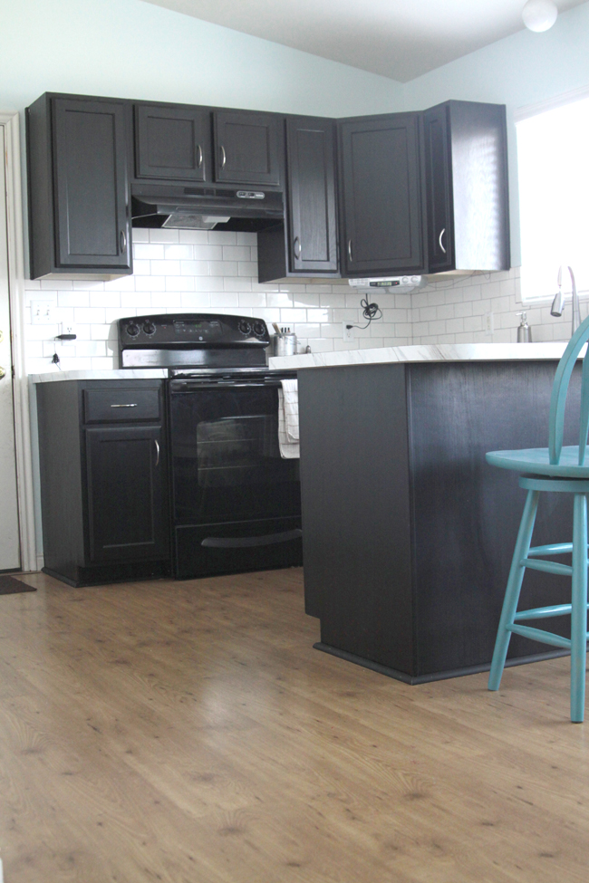 A kitchen with black cabinetry