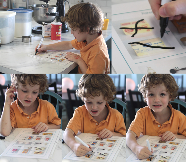 A boy marking off ingredients on illustrated cookie recipe sheet